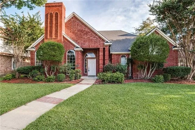 Red brick home at 2700 Trophy Dr in Plano with a landscaped front yard